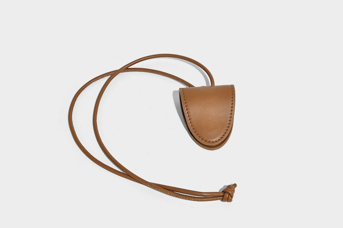 Small structured woven tote crossbody bag with ring top handle, leather-look brown trim, front patch pocket, and detachable