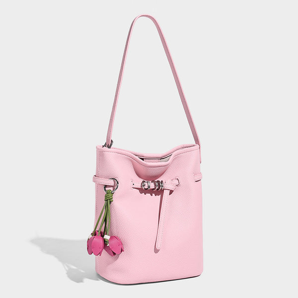 Small pebbled leather-look bucket bag with front drawstring toggle hardware and long adjustable shoulder strap, front view