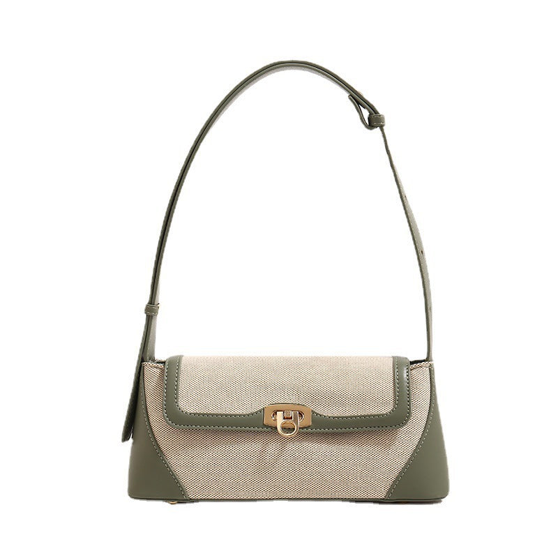 Structured trapezoid flap shoulder bag with canvas-textured body, smooth contrast trim, and gold-tone turn-lock clasp, detail