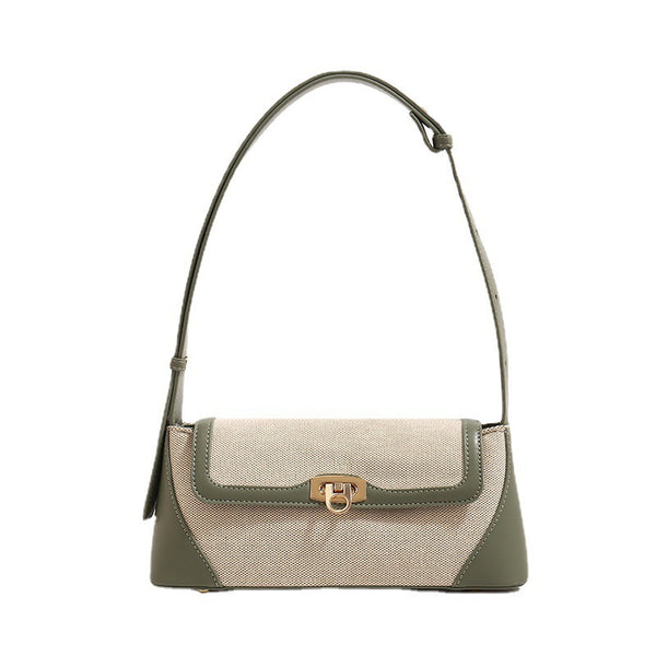 Structured trapezoid flap shoulder bag with canvas-textured body, smooth contrast trim, and gold-tone turn-lock clasp, detail