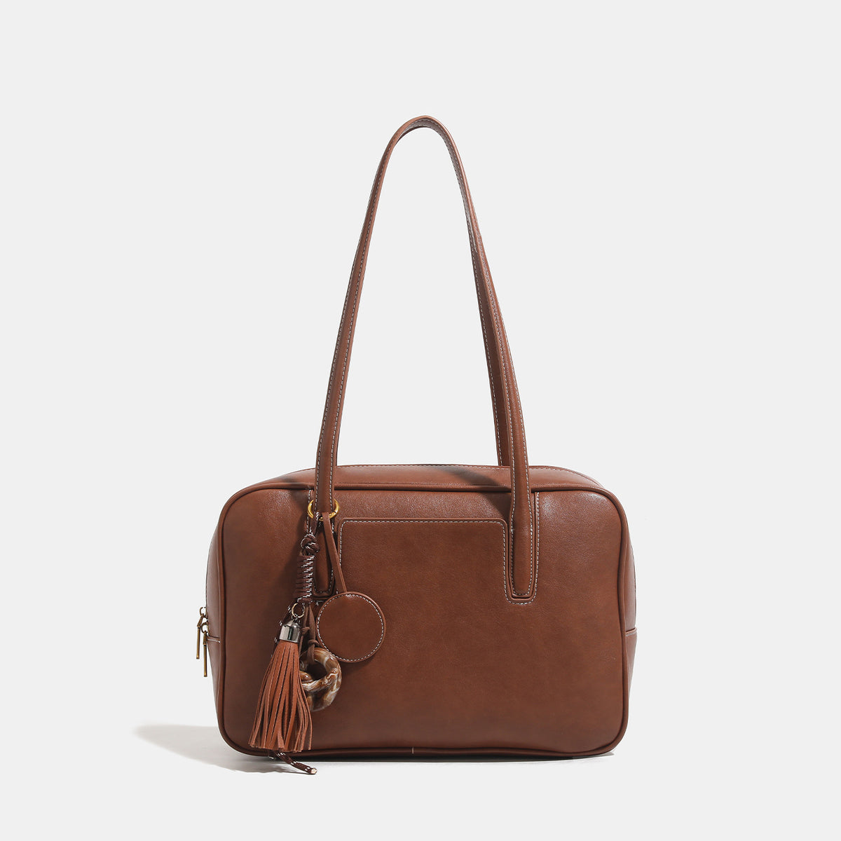 Structured rectangular leather-look shoulder bag with top zip, tassel and resin ring charm, and contrast topstitching, detail