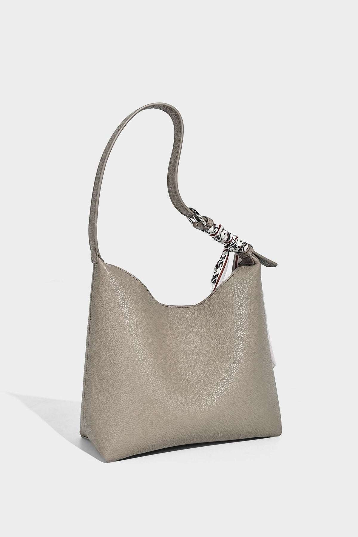 Soft slouchy hobo shoulder bag in pebbled matte finish with slim strap, silver-tone ring hardware, and knotted printed scarf