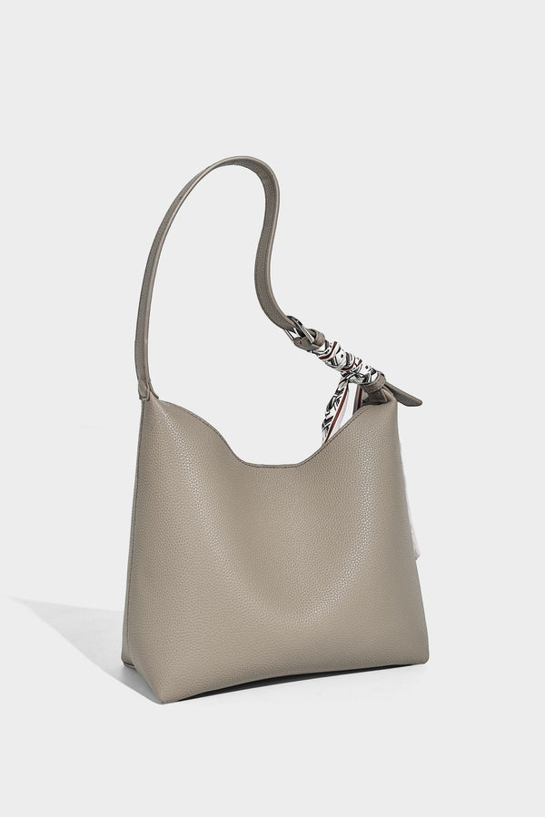 Soft slouchy hobo shoulder bag in pebbled matte finish with slim strap, silver-tone ring hardware, and knotted printed scarf