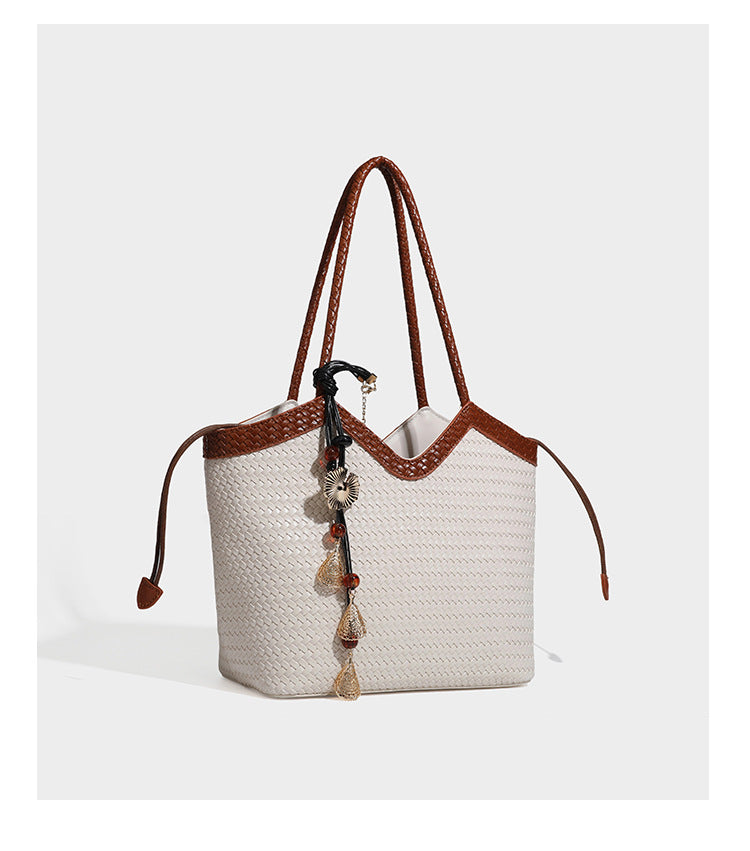 Woven tote bag with braided shoulder straps, drawstring closure, and dangling metal-and-bead charm, detail view 22