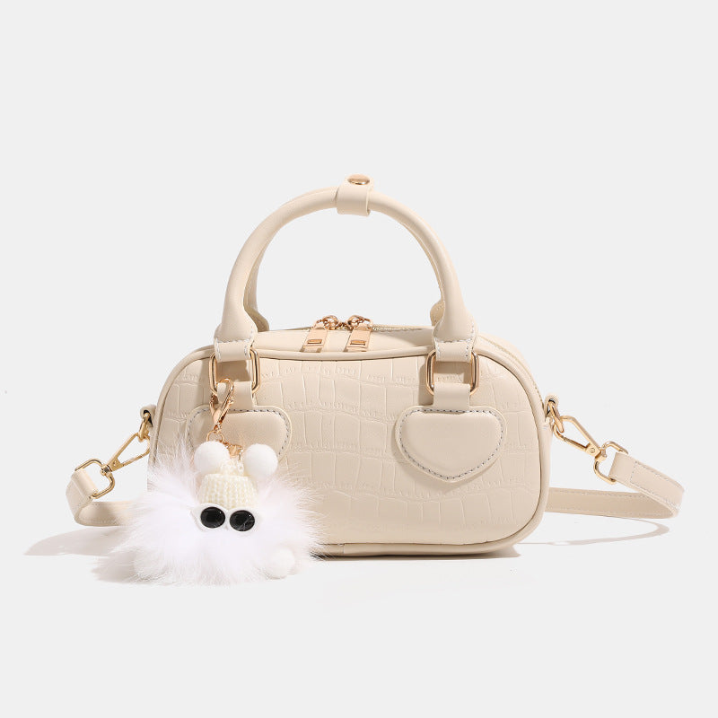 Mini croc-embossed barrel handbag with gold-tone hardware, dual zip top handles, detachable crossbody strap, and fluffy
