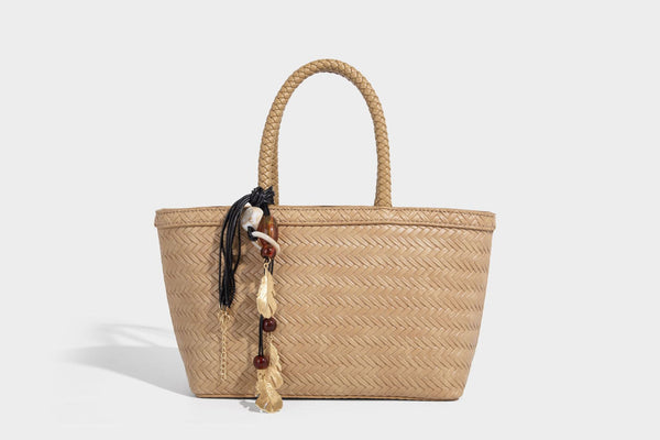 Structured chevron woven leather-look tote bag with braided top handles, gold feather charm, and adjustable shoulder strap