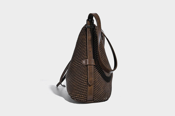 Große Schultertasche in Beutelform mit Flechtoptik, glatten Besätzen in Lederoptik, verstellbarem Riemen und hängendem Anhänger-Detail, Detailansicht