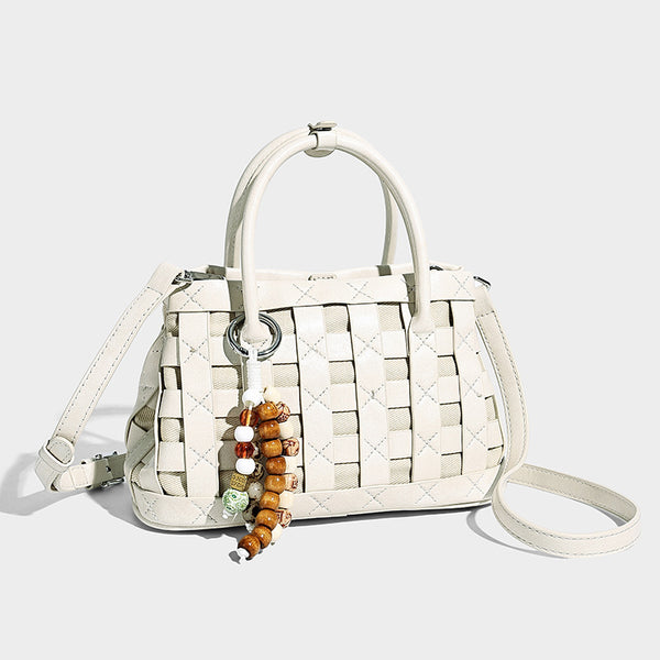 Small structured woven satchel tote with rounded top handles, silver-tone ring hardware, and bead tassel charm, front view