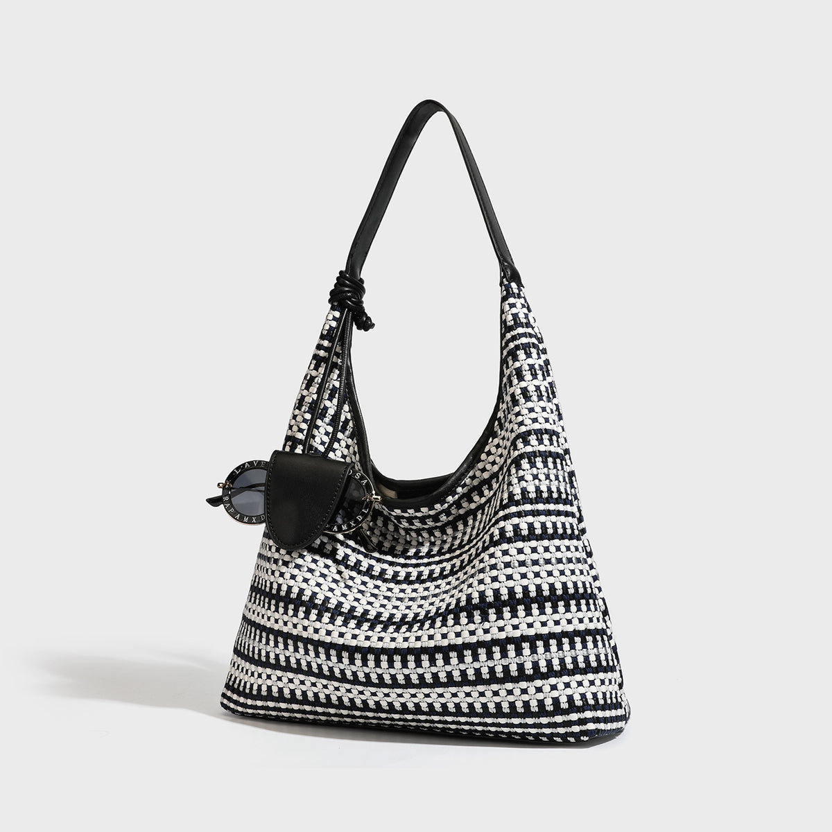 Slouchy woven stripe hobo shoulder bag with black-and-white pattern and leather-look strap, front view