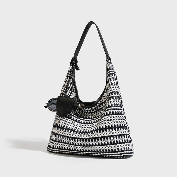 Slouchy woven stripe hobo shoulder bag with black-and-white pattern and leather-look strap, front view