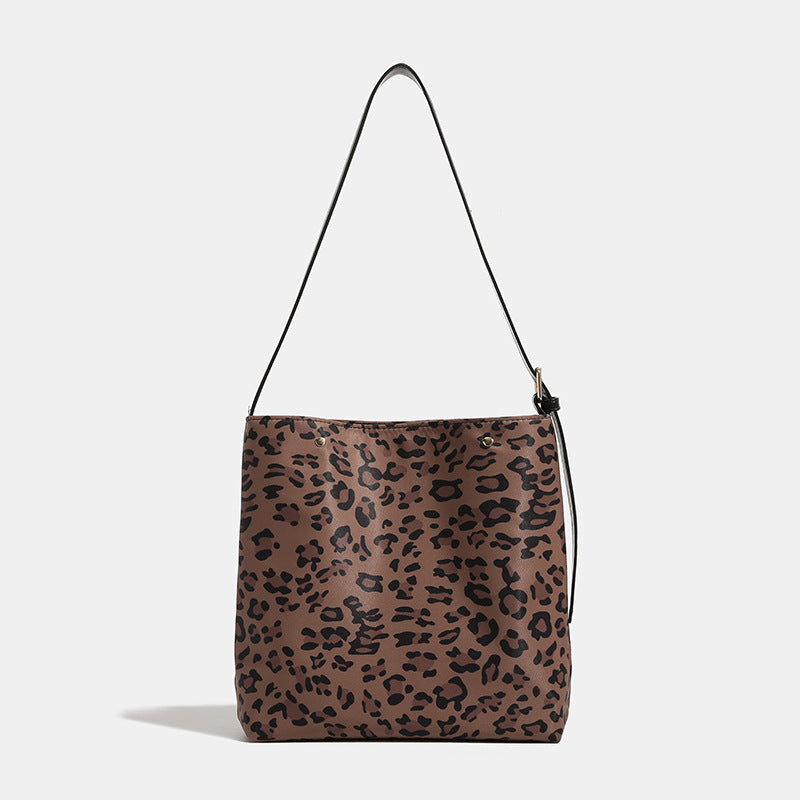 Beuteltasche aus Canvas mit braun-schwarzem Leopardenmuster, verstellbarem schwarzen Schulterriemen in Lederoptik und goldfarbenen Beschlägen