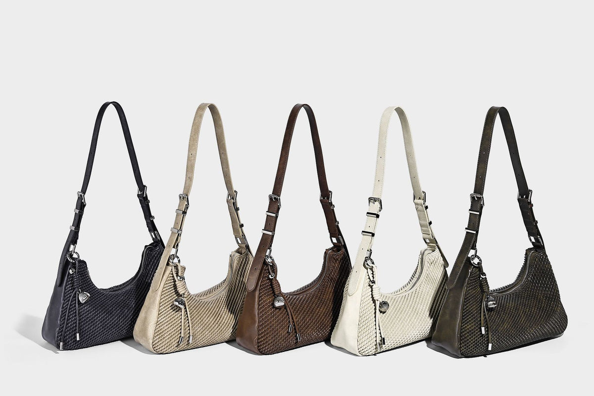 Woven crescent hobo shoulder bag with smooth side panels, zip-top closure, silver-tone charm hardware, and adjustable, detail