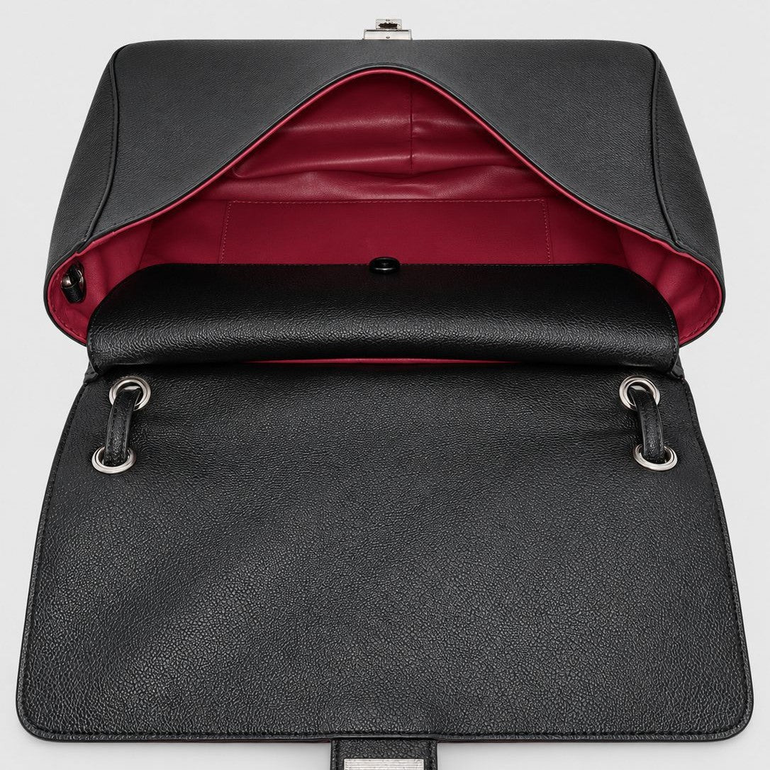 Structured black flap shoulder bag with pebbled texture, silver-tone turn-lock closure, and adjustable single shoulder strap
