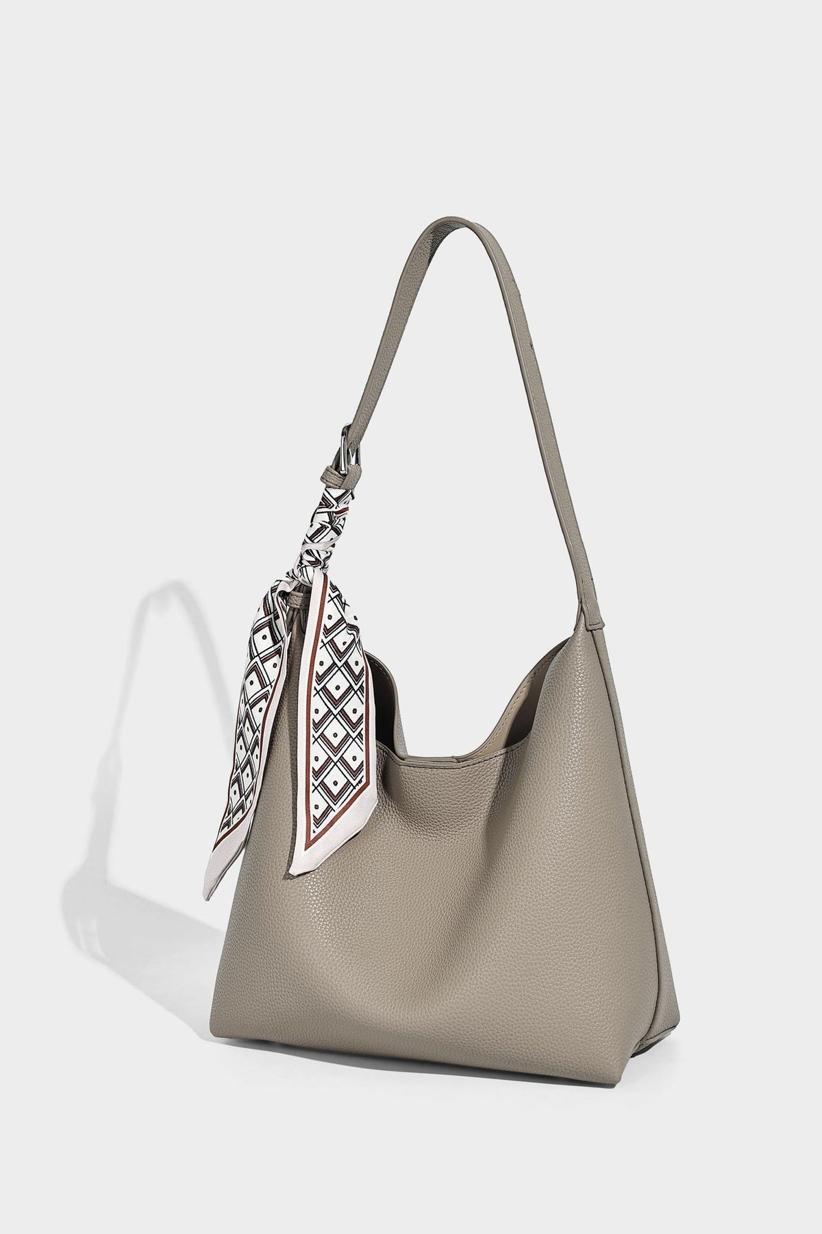 Soft slouchy hobo shoulder bag in pebbled matte finish with slim strap, silver-tone ring hardware, and knotted printed scarf
