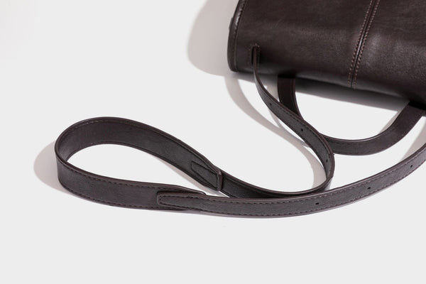Strukturierte Satchel-Tasche mit Überschlag aus dunkelbrauner, glänzender Lederoptik, kurzem Tragegriff und langem, verstellbarem Schulterriemen