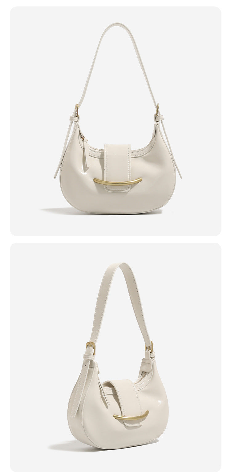 Compact crescent hobo shoulder bag with glossy synthetic finish, curved gold-tone front bar hardware, zip-top closure, and