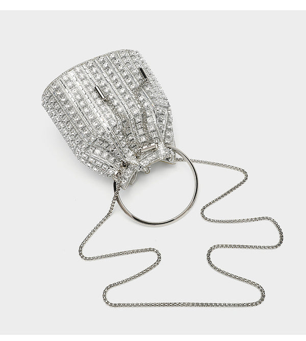 Mini crystal rhinestone bucket bag with circular ring top handle, drawstring closure, and silver chain shoulder strap, detail
