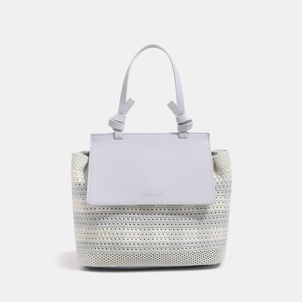 Structured woven tote bag with smooth leather-look front flap panel, knotted top handles, and detachable crossbody strap