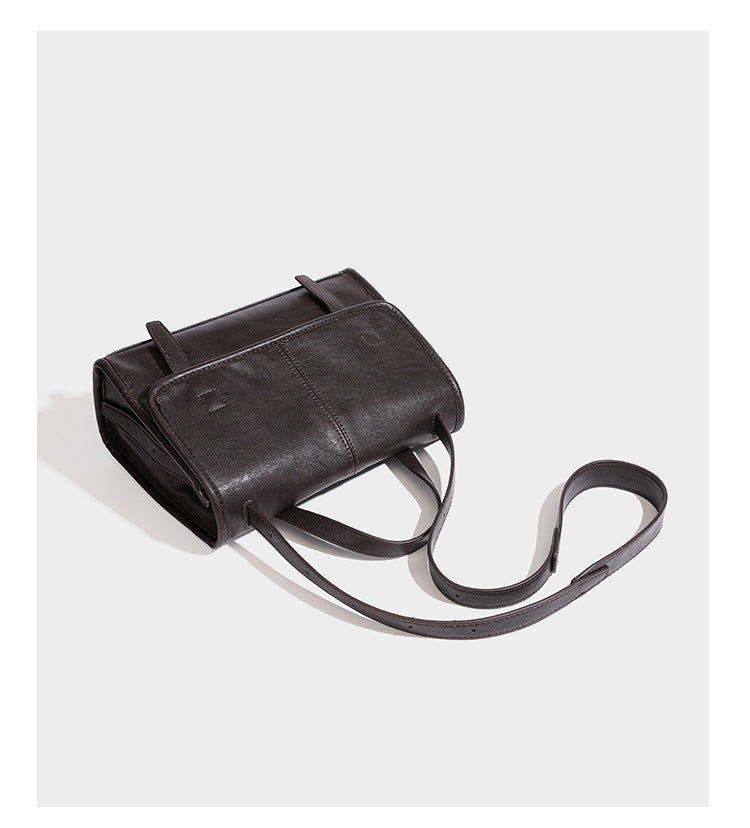 Strukturierte Satchel-Tasche mit Überschlag aus dunkelbrauner, glänzender Lederoptik, kurzem Tragegriff und langem, verstellbarem Schulterriemen