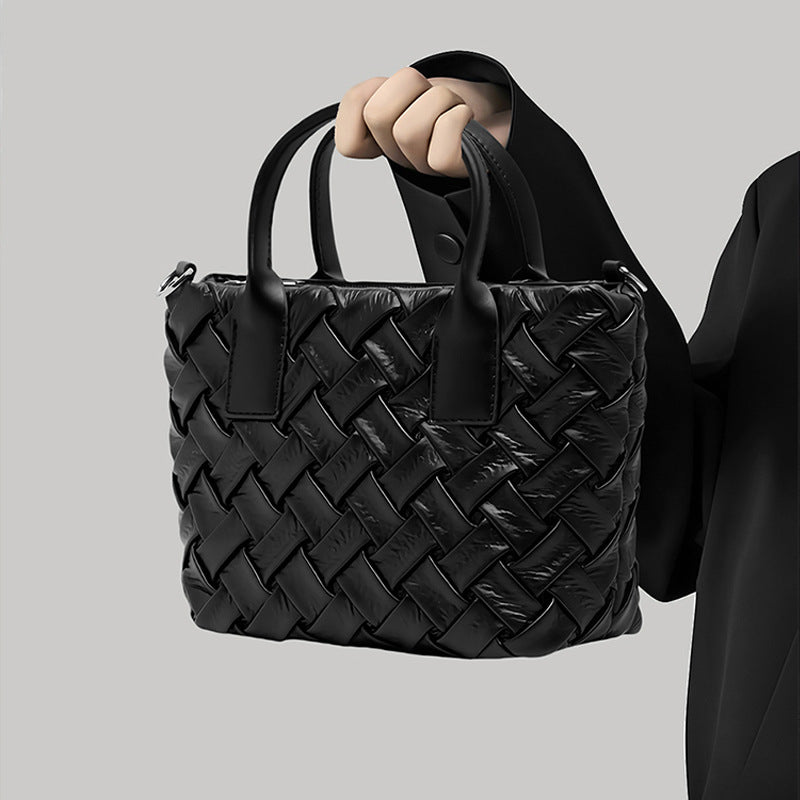 Small black glossy woven tote bag with dual top handles and detachable shoulder strap, detail view 6