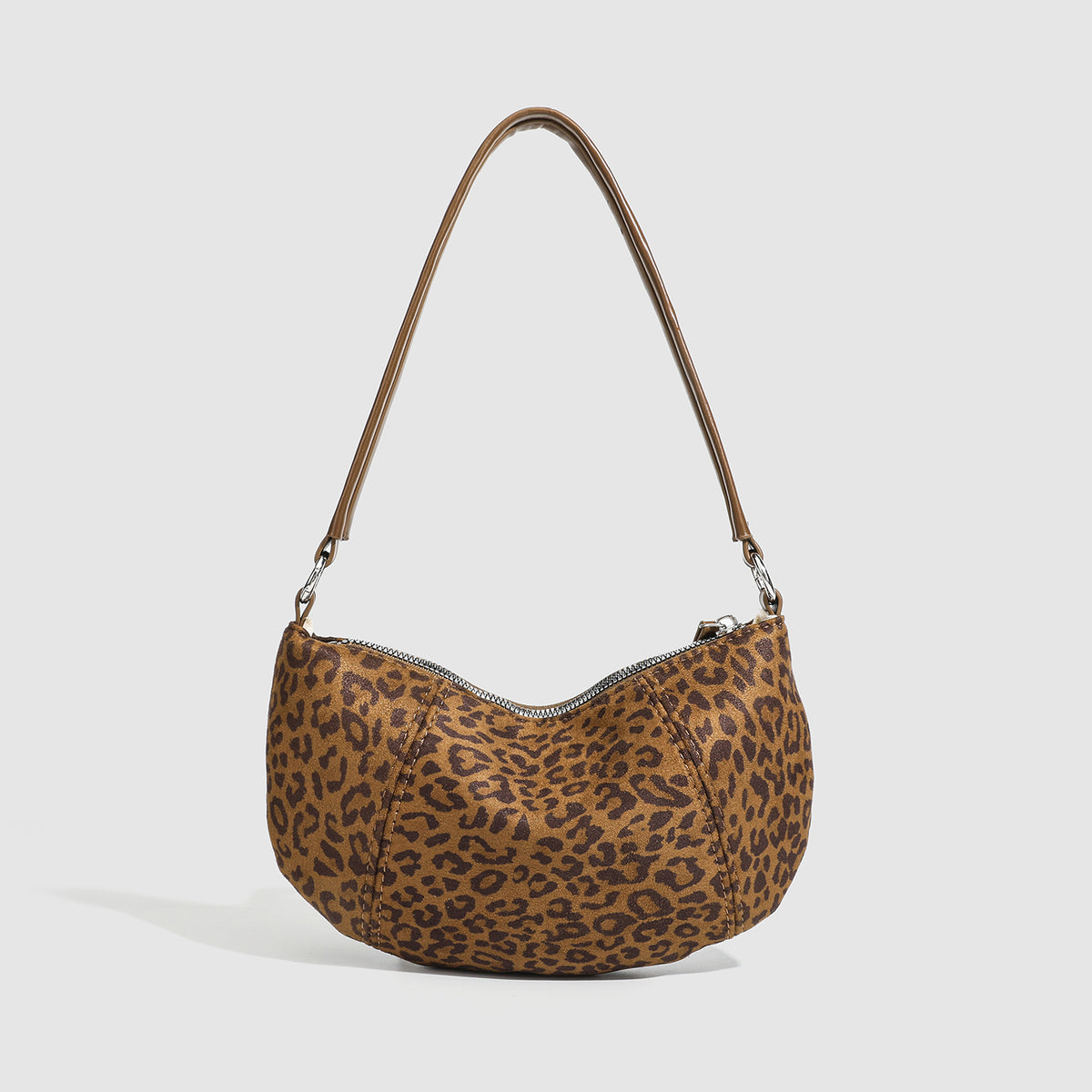 Brown and tan leopard print crescent hobo shoulder bag with zip top closure, front zip pocket, and adjustable silver-tone