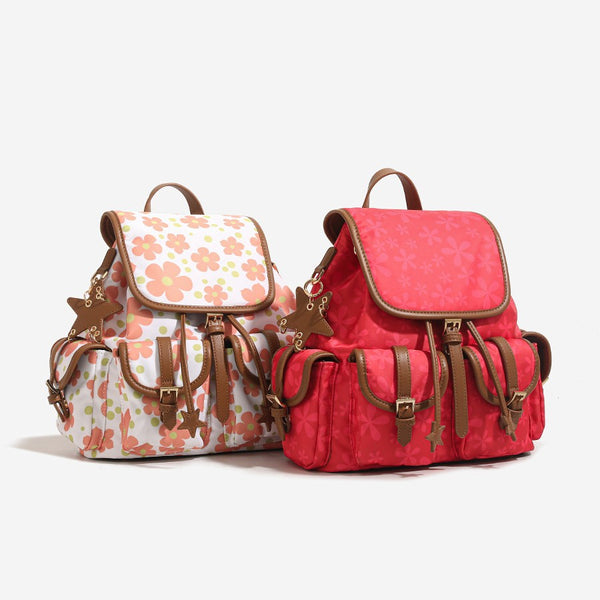 Red floral-print backpack handbag with brown leather-look trim, dual front buckle pockets, star charms, and gold-tone, front