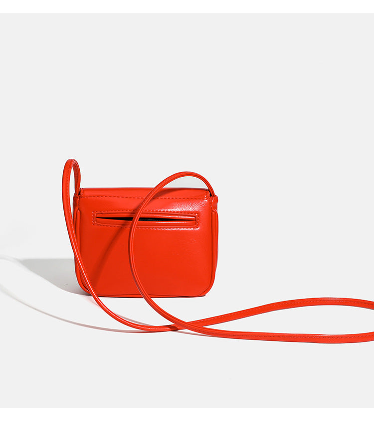 Compact rounded rectangular flap crossbody bag with glossy leather-look finish and long shoulder strap, detail view 13