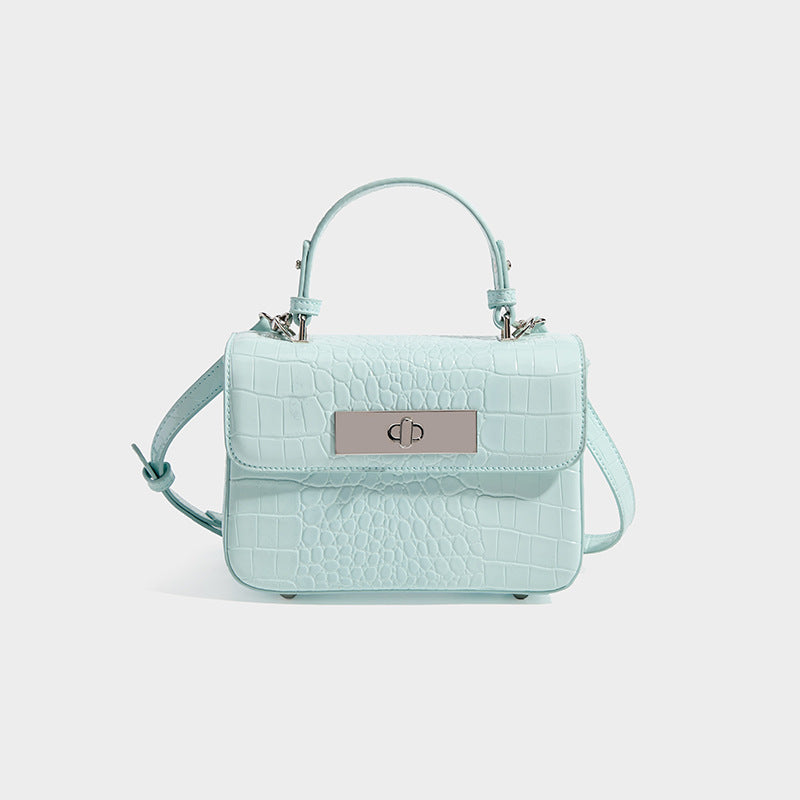 Small structured rectangular satchel with glossy crocodile-embossed finish, arched top handle, front flap, and silver-tone