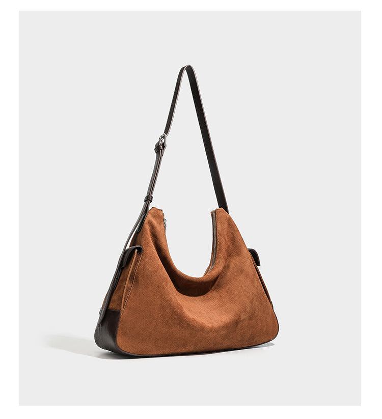Cognac brown suede-look slouchy shoulder bag with dark brown leather-look trim, top zip closure, exterior side pocket, and