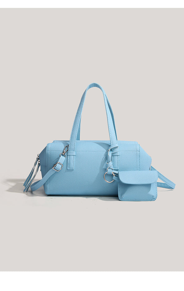 Light blue pebbled matte Boston tote bag with top handles, detachable shoulder strap, metal ring hardware, and matching mini
