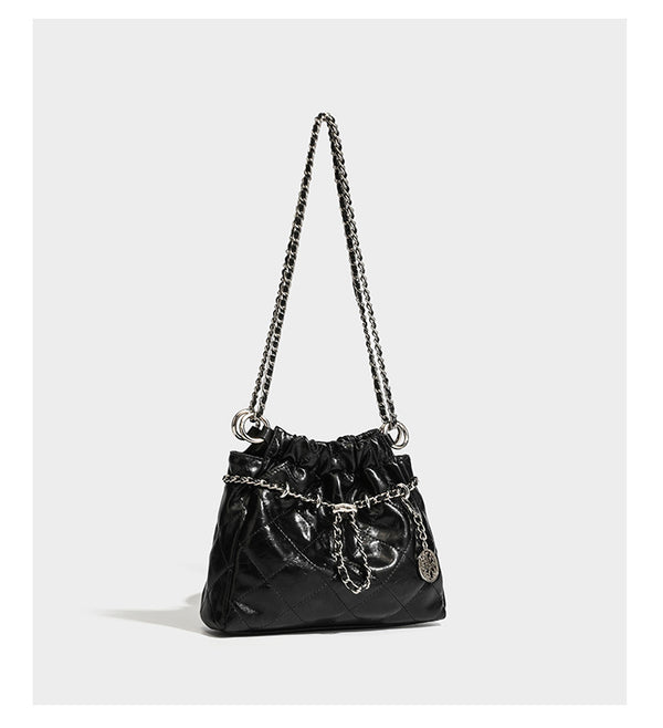 Glossy diamond-quilted drawstring bucket bag with silver chain shoulder strap and medallion charm, detail view 10