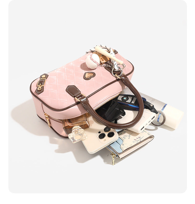 Small structured blush pink quilted diamond Boston barrel bag with brown leather-look trim, double top handles, heart accent