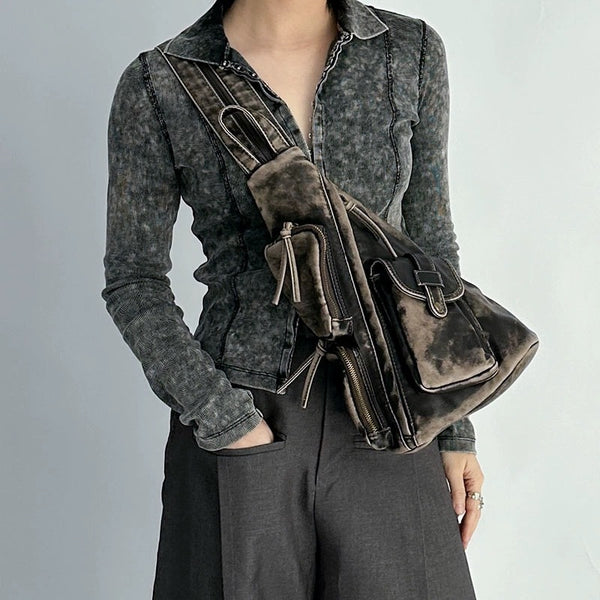 Dreieckiger Sling-Rucksack aus Used-PU in Oliv mit mehreren Reißverschlussfächern, Druckknopfklappe, Beschlägen in Goldoptik und