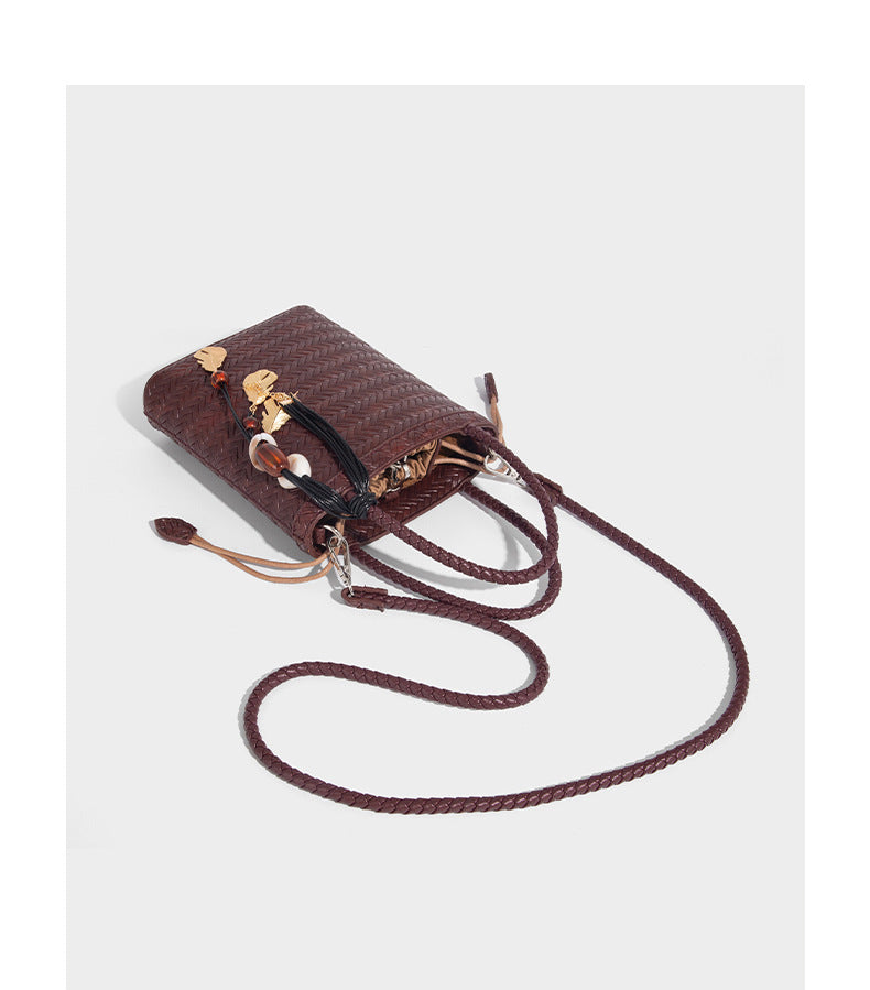 Small structured woven-texture tote bag with braided top handles and drawstring inner pouch, detail view 16