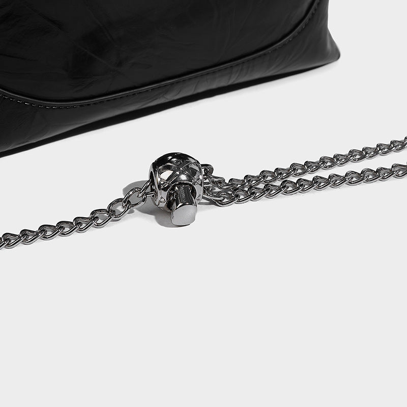 Glossy crinkled ruched drawstring bucket bag with rounded double top handles and detachable chain crossbody strap, detail