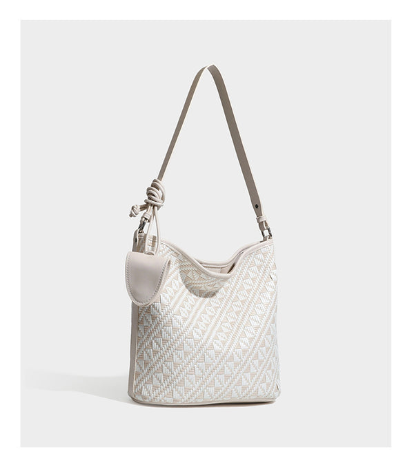 Geflochtene Schultertasche mit geometrischem Ethno-Muster, Besatz in dunkelbrauner Lederoptik, langem verstellbarem Träger und kleinem hängendem Reißverschluss