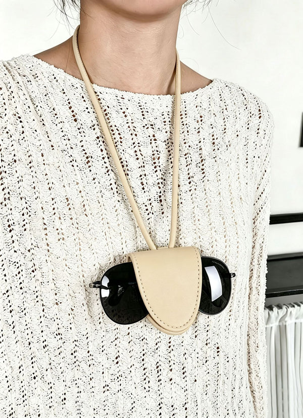 Small woven crescent shoulder bag with leather-look trim, zip closure, silver-tone ring hardware, and beaded tassel charm