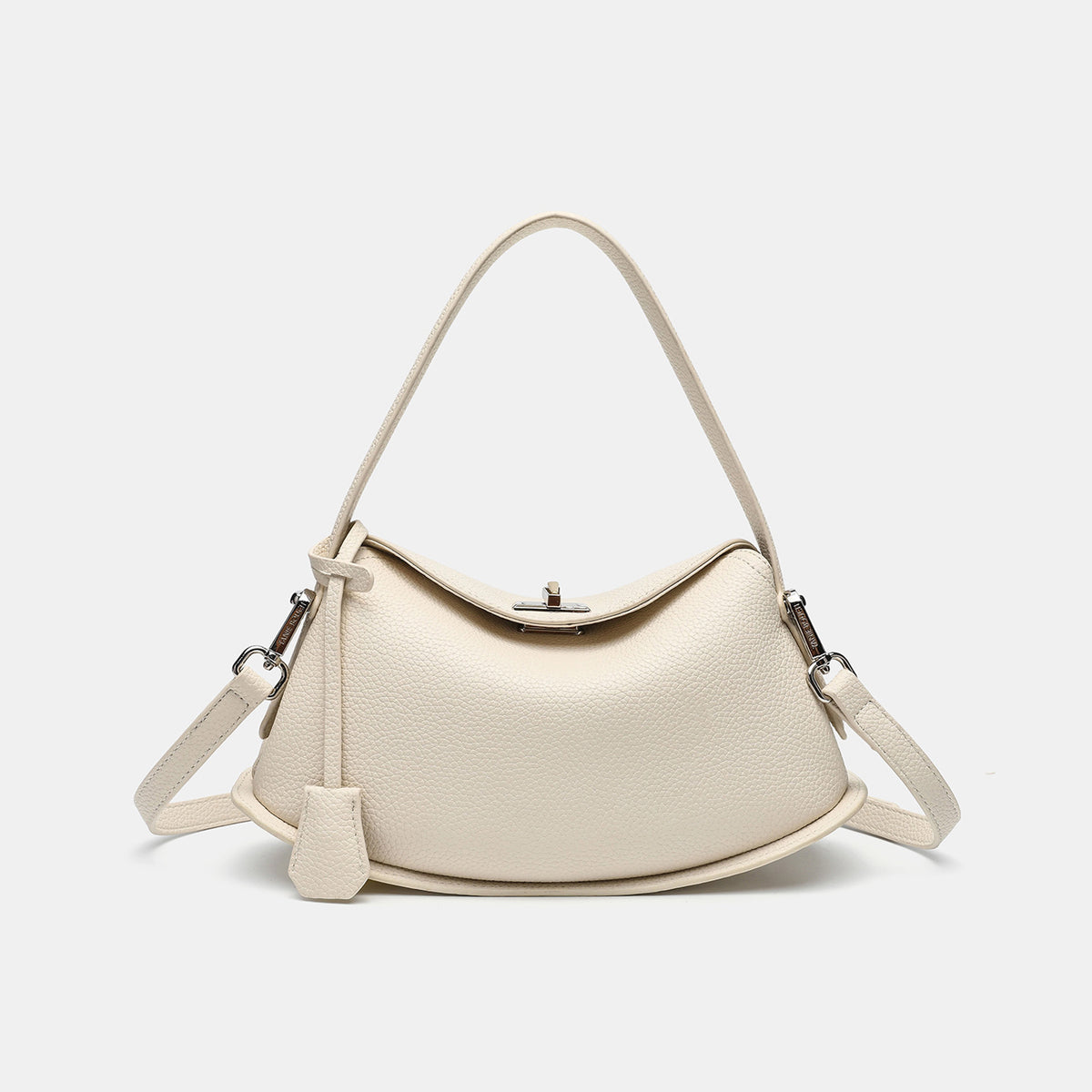 Pebbled leather-look half-moon saddle bag with turn-lock flap closure, top handle, and detachable crossbody strap, detail