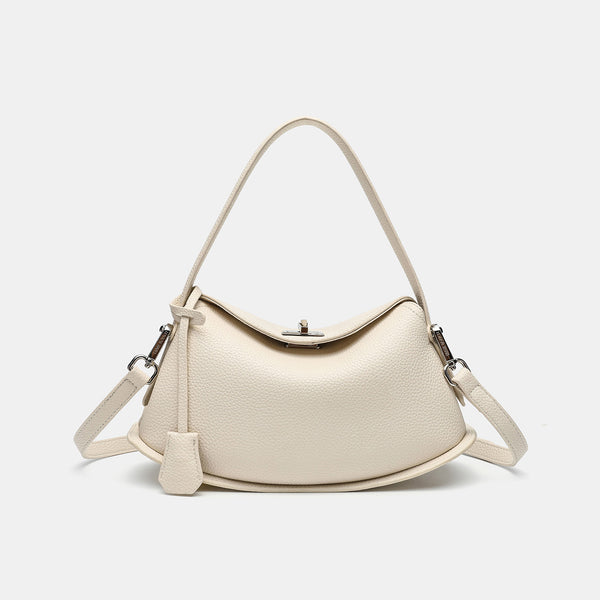 Pebbled leather-look half-moon saddle bag with turn-lock flap closure, top handle, and detachable crossbody strap, detail