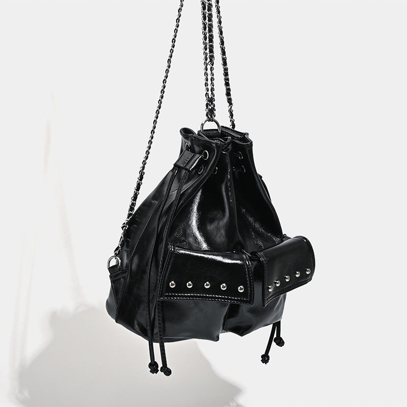 Glossy leather-look drawstring bucket bag with silver dome studs and chain shoulder strap, detail view 3
