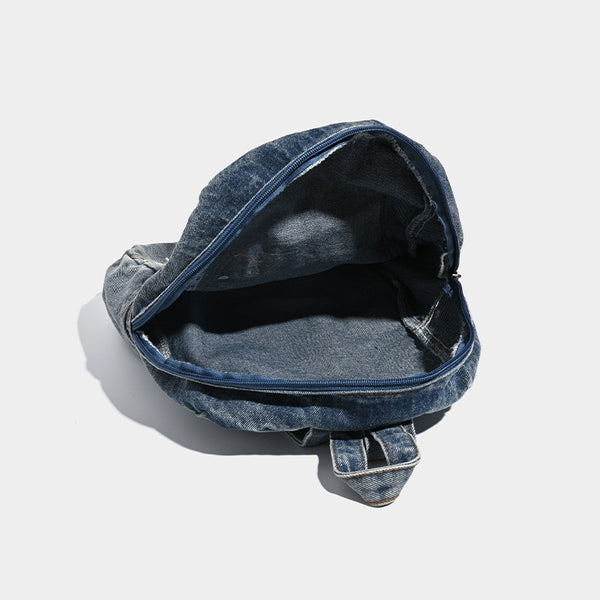 Rucksack aus gewaschenem blauem Denim mit weißer Schnürung auf der Vorderseite, ausgefranstem, herzförmigem besticktem Außenfach und Reißverschluss oben