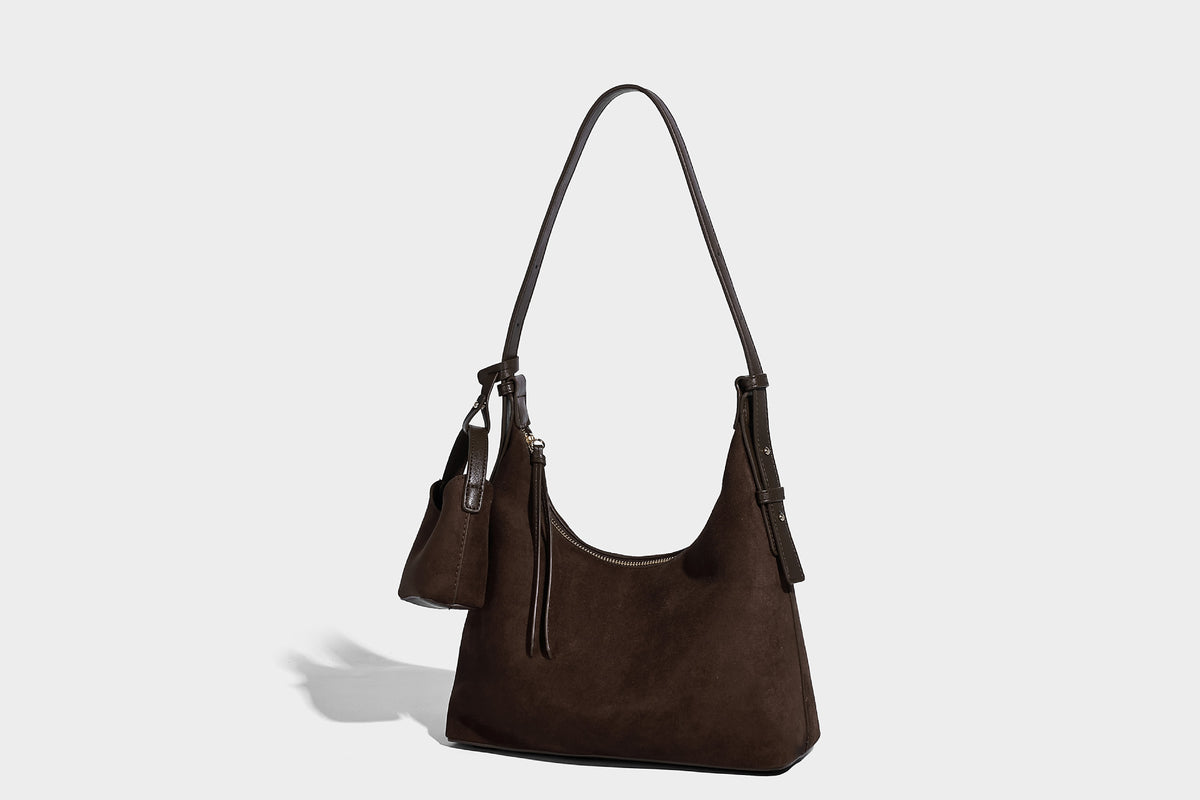 Dark brown suede-look hobo shoulder bag with top zip closure, adjustable strap, and small detachable mini pouch, detail view
