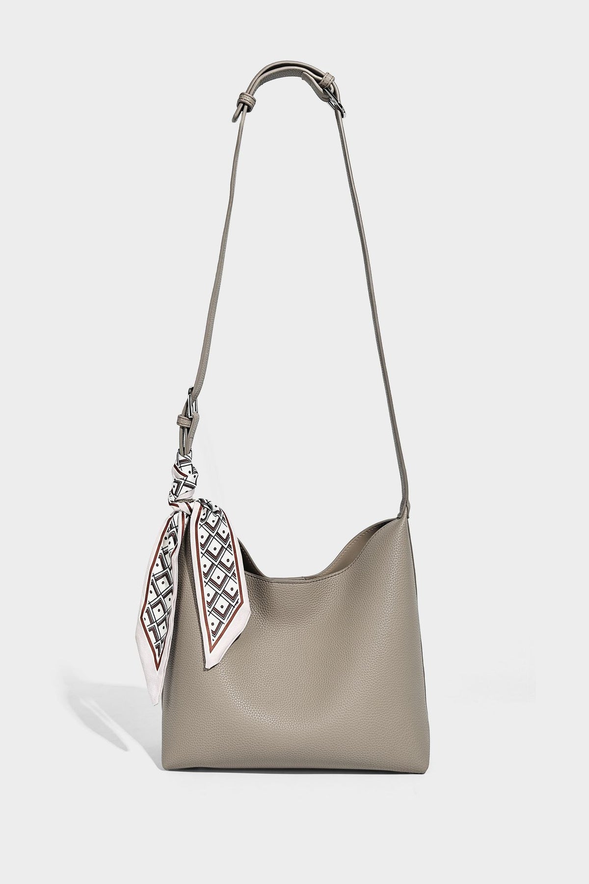Soft slouchy hobo shoulder bag in pebbled matte finish with slim strap, silver-tone ring hardware, and knotted printed scarf