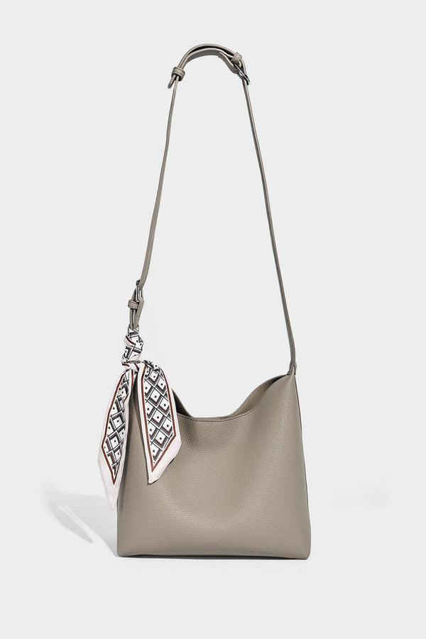 Soft slouchy hobo shoulder bag in pebbled matte finish with slim strap, silver-tone ring hardware, and knotted printed scarf