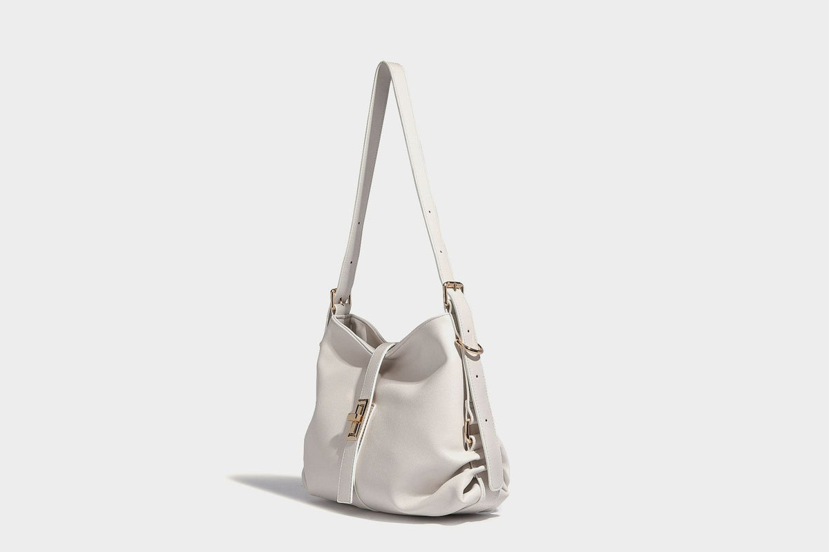 Soft slouchy hobo shoulder bag with smooth leather-look finish, gold-tone buckle and tab hardware, and long adjustable strap