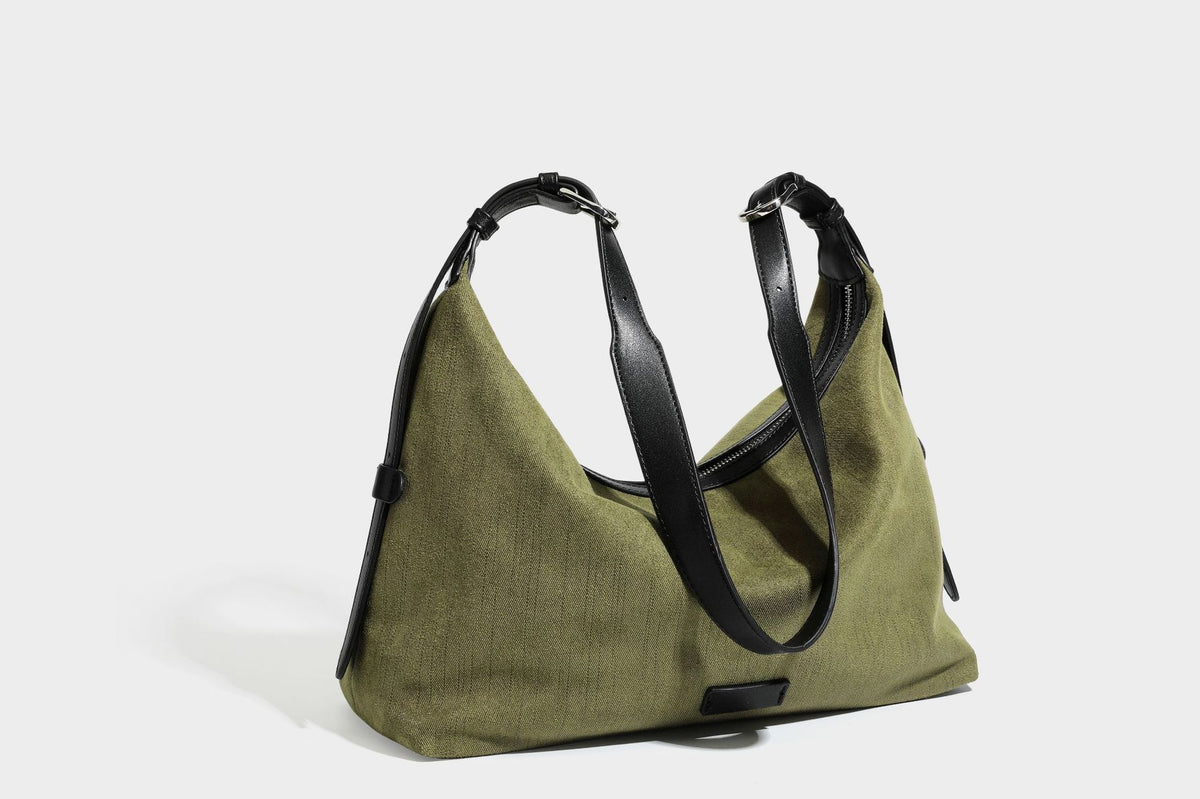 Slouchy olive green canvas hobo shoulder bag with black leather-look trim, zip-top closure, and adjustable strap, detail view