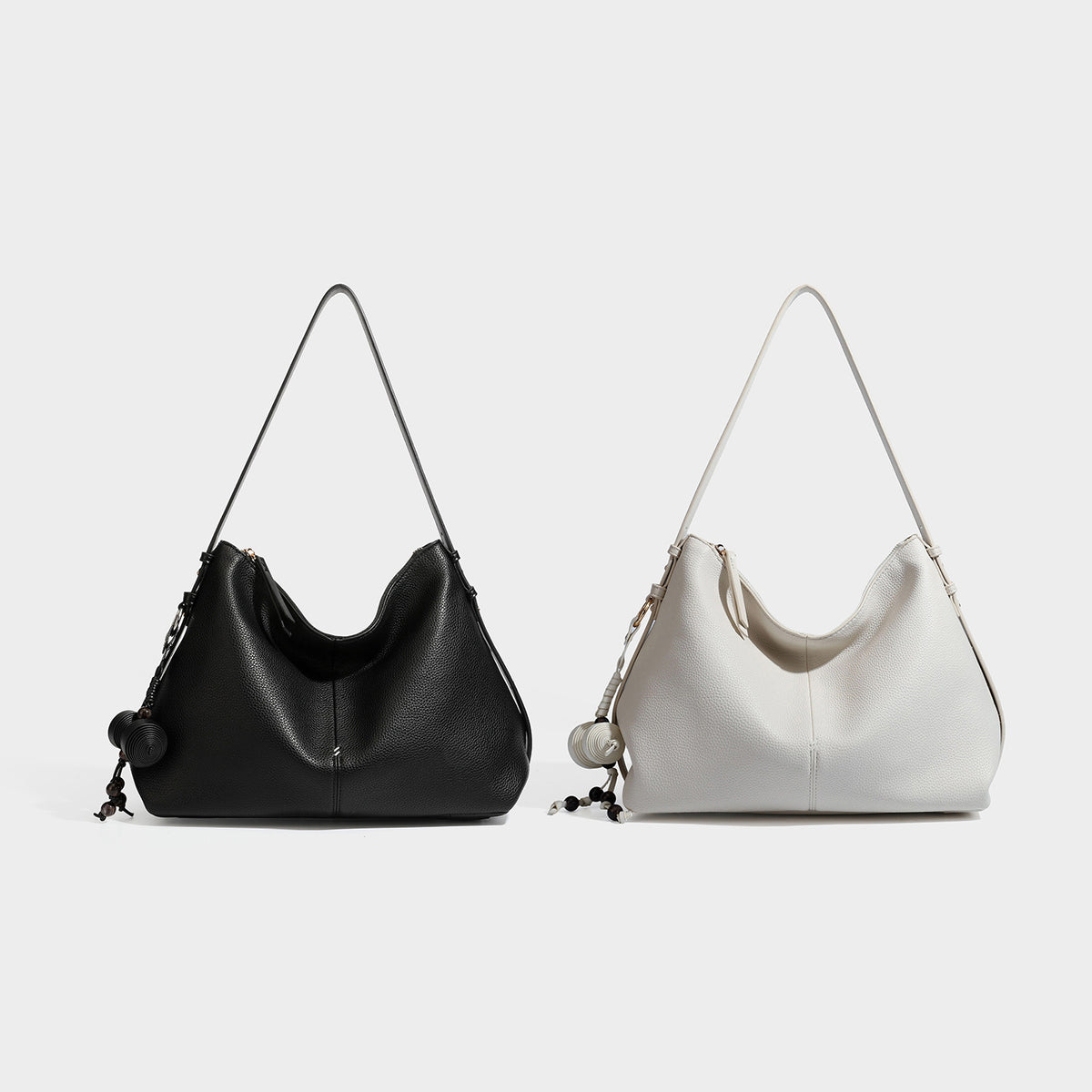 Weiche Hobo-Schultertasche mit genarbter Lederoptik, Reißverschluss oben, goldfarbenen Beschlägen und herabhängendem Perlenanhänger