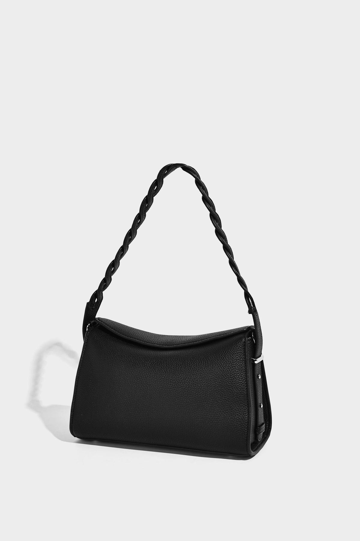 Small structured pebbled-finish shoulder bag with braided top handle, detachable crossbody strap, floral tassel charm, and