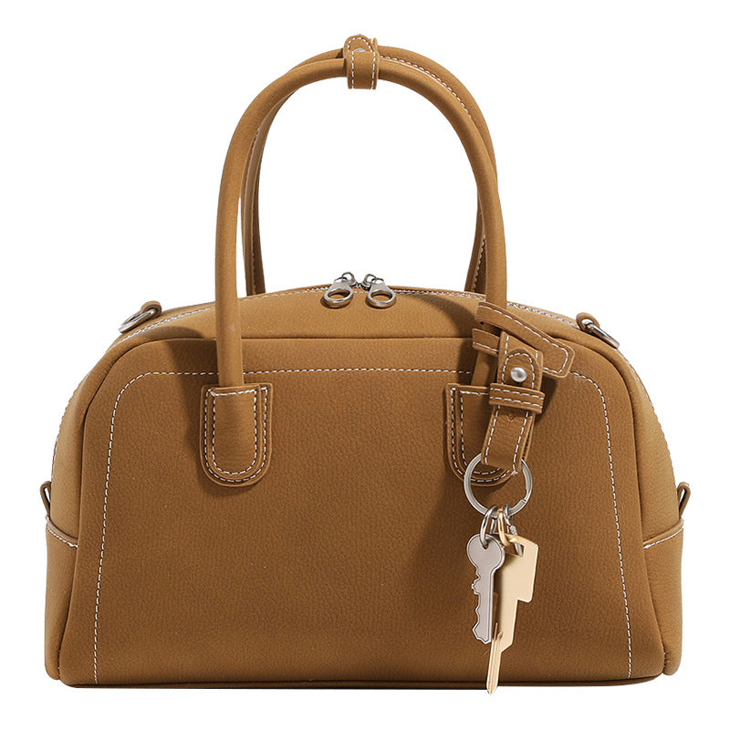 Compact retro Boston satchel bag with matte suede-look finish, twin rounded top handles, double zip closure with silver-tone