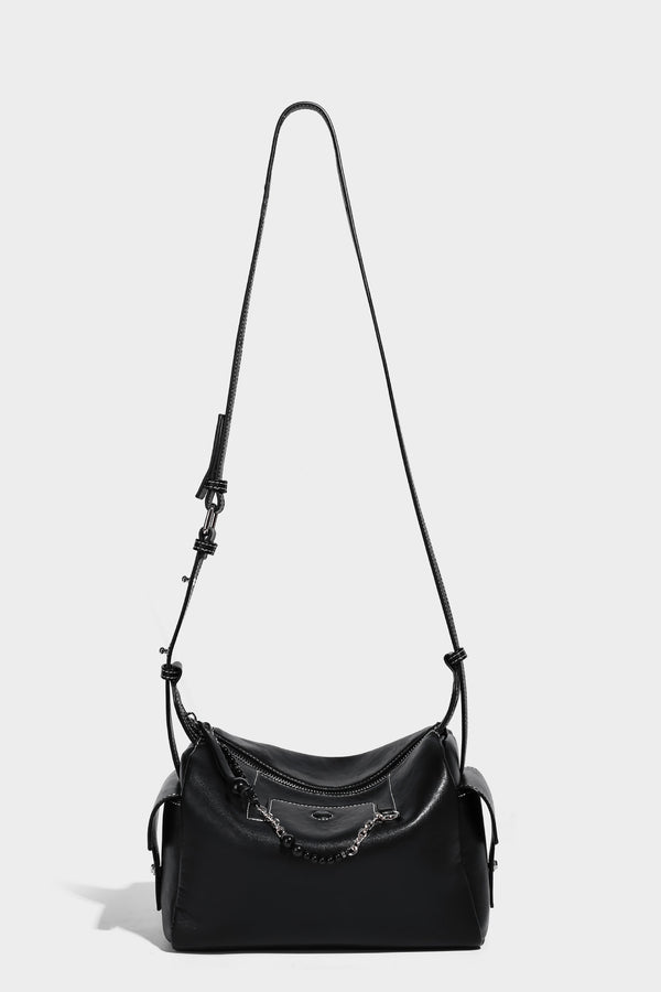 Small slouchy moto-style crossbody bag in smooth matte leather-look finish with white contrast stitching, silver-tone, detail